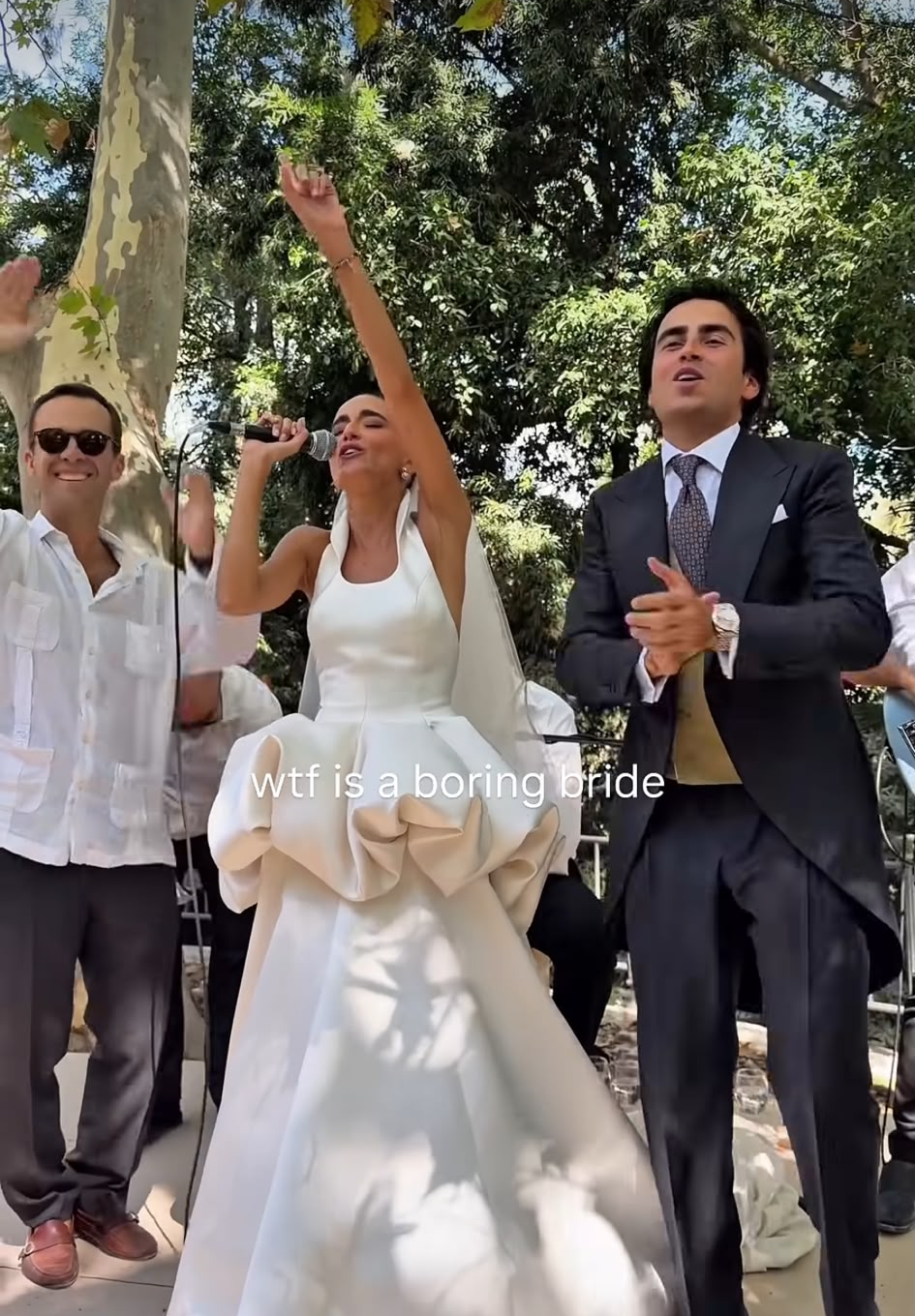 Natichu con el micrófono y el novio dando palmas durante el cóctel
